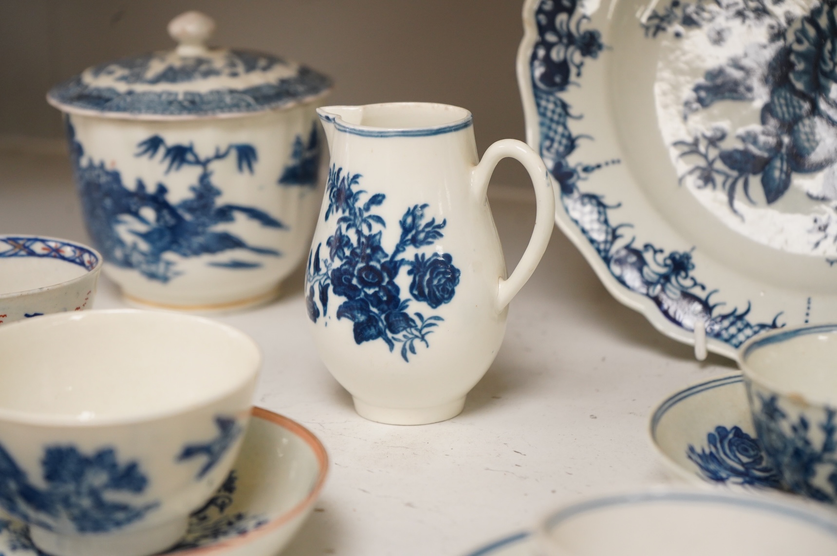 A collection of late 18th century Worcester, Caughley and Liverpool blue and white tea wares to include tea bowls and saucers, jug, suger basin and cover and two dishes etc, largest 23cm in diameter